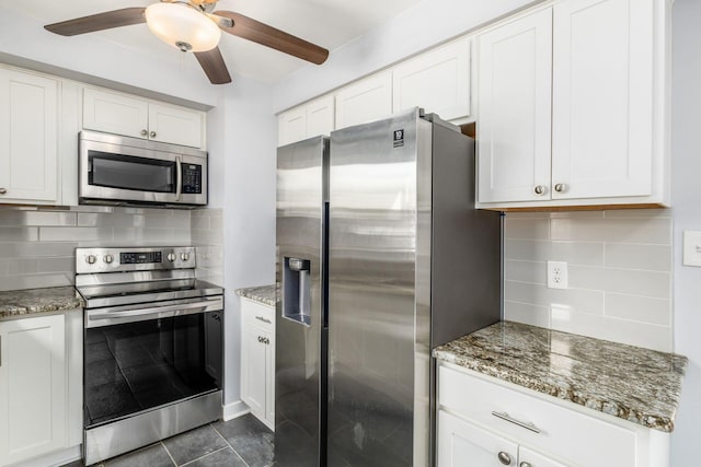 kitchen featuring stone counters, tasteful backsplash, appliances with stainless steel finishes, and a ceiling fan