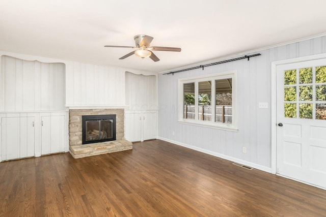 unfurnished living room featuring visible vents, a ceiling fan, a fireplace, baseboards, and dark wood-style flooring