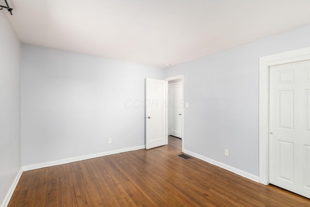 unfurnished bedroom featuring visible vents, baseboards, and wood finished floors