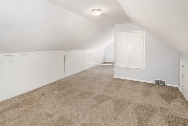 bonus room featuring lofted ceiling, carpet flooring, and visible vents