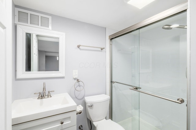 full bath featuring vanity, toilet, visible vents, and a stall shower