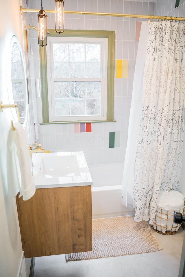 bathroom featuring tile patterned flooring, vanity, an inviting chandelier, and shower / bath combo with shower curtain