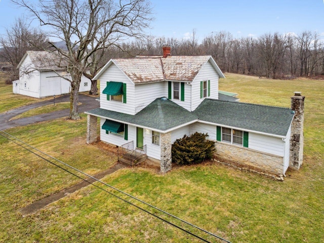 traditional home featuring a front lawn, stone siding, roof with shingles, and a chimney