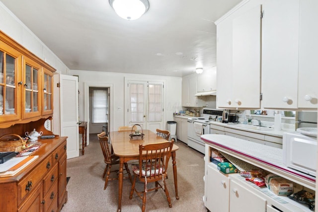 dining space with crown molding and light colored carpet