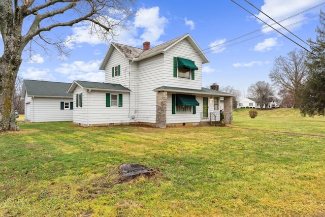 back of property with crawl space, a chimney, and a yard