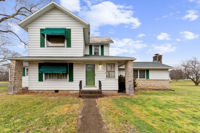 traditional-style house featuring a front yard and a chimney