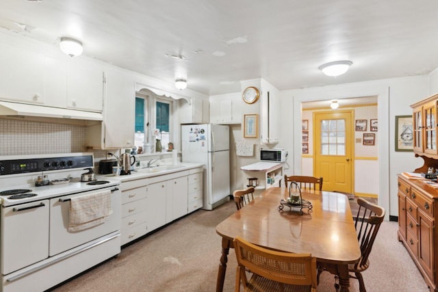 kitchen featuring white appliances, a sink, light countertops, white cabinets, and under cabinet range hood