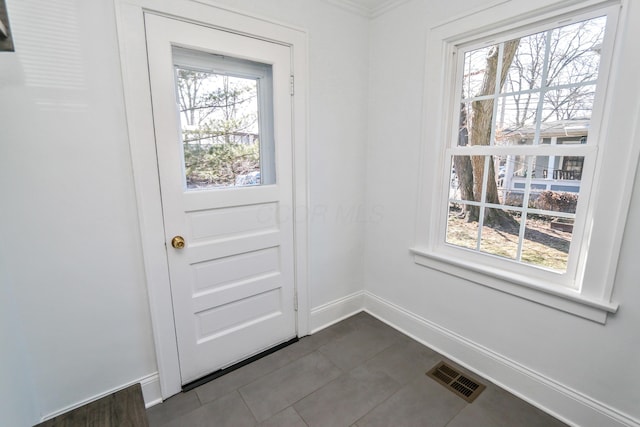 doorway with dark tile patterned floors