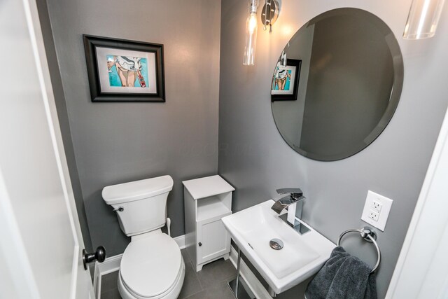 bathroom featuring sink, toilet, and tile patterned flooring