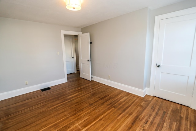 empty room featuring dark wood-type flooring