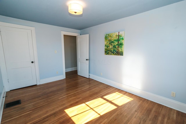 unfurnished bedroom with dark hardwood / wood-style flooring