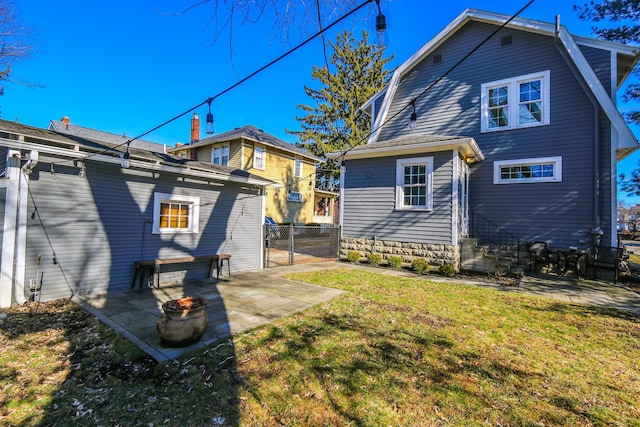 rear view of property featuring a patio and a lawn