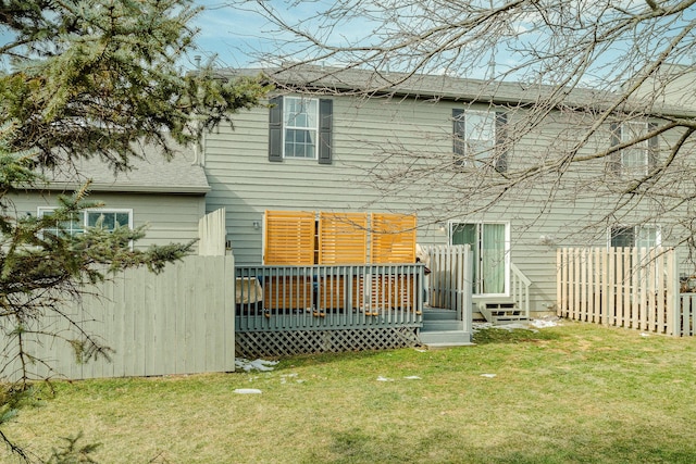 rear view of property featuring a deck and a lawn