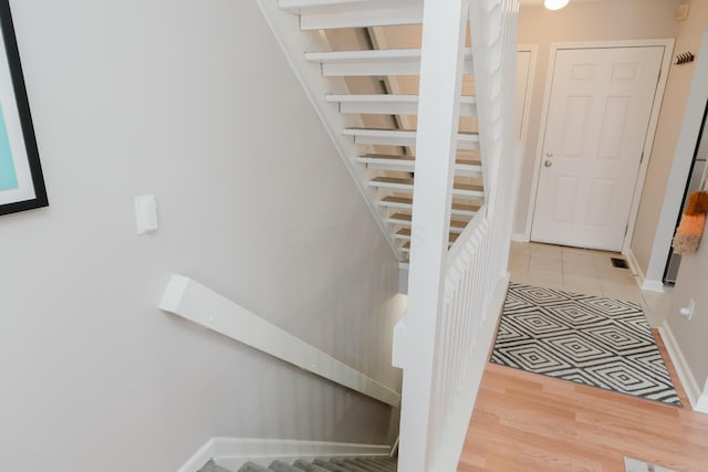 stairway featuring tile patterned flooring