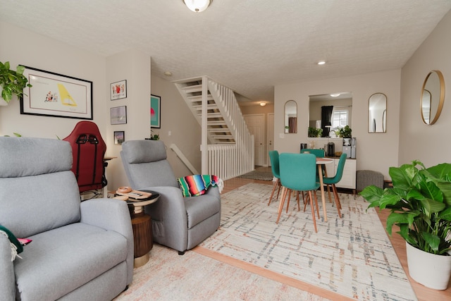 living room with light hardwood / wood-style floors and a textured ceiling