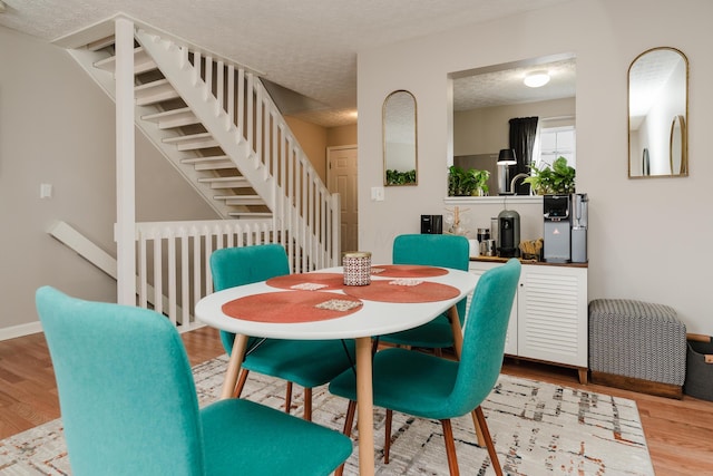 dining space featuring hardwood / wood-style floors and a textured ceiling