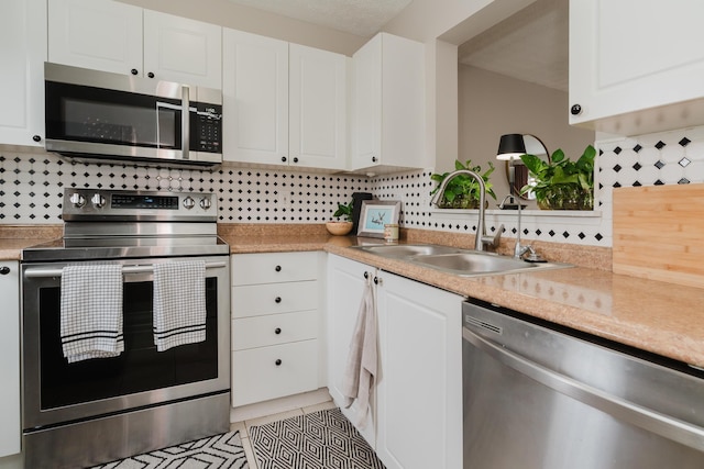 kitchen featuring white cabinetry, appliances with stainless steel finishes, sink, and backsplash