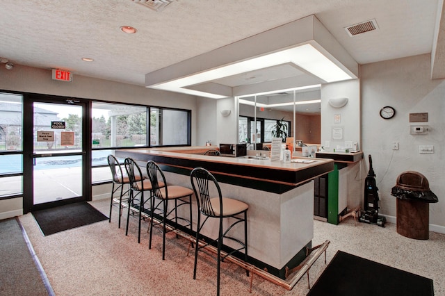 kitchen with a breakfast bar area, kitchen peninsula, and a textured ceiling