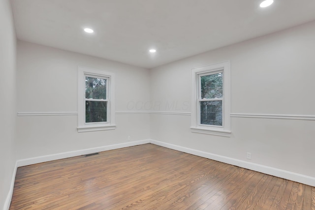 empty room with wood-type flooring and a healthy amount of sunlight