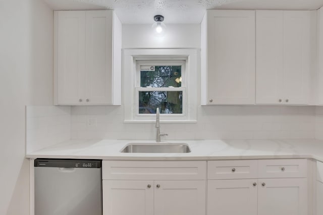 kitchen with sink, tasteful backsplash, light stone counters, white cabinets, and stainless steel dishwasher