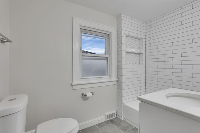 full bathroom featuring vanity, tiled shower / bath, tile patterned flooring, and toilet