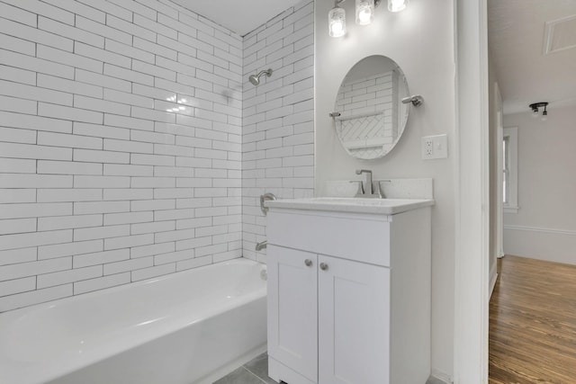 bathroom featuring vanity, hardwood / wood-style flooring, and tiled shower / bath