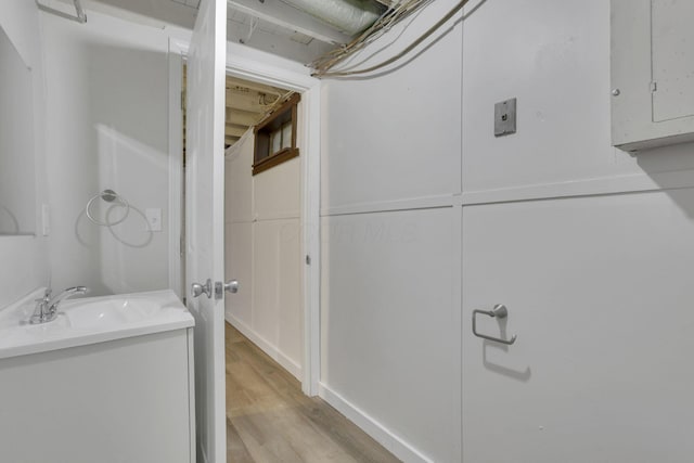 bathroom featuring hardwood / wood-style flooring, vanity, and electric panel