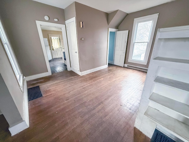 unfurnished living room featuring a baseboard radiator and dark hardwood / wood-style flooring