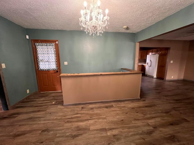 kitchen featuring decorative light fixtures, a chandelier, a textured ceiling, dark hardwood / wood-style floors, and white fridge with ice dispenser