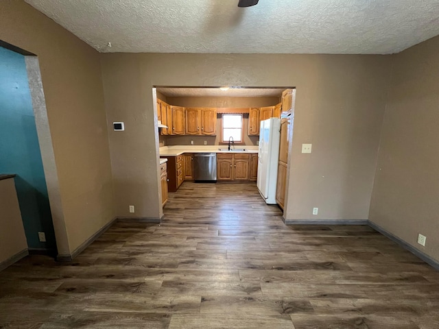 kitchen with sink, dark wood-type flooring, a textured ceiling, stainless steel dishwasher, and white fridge