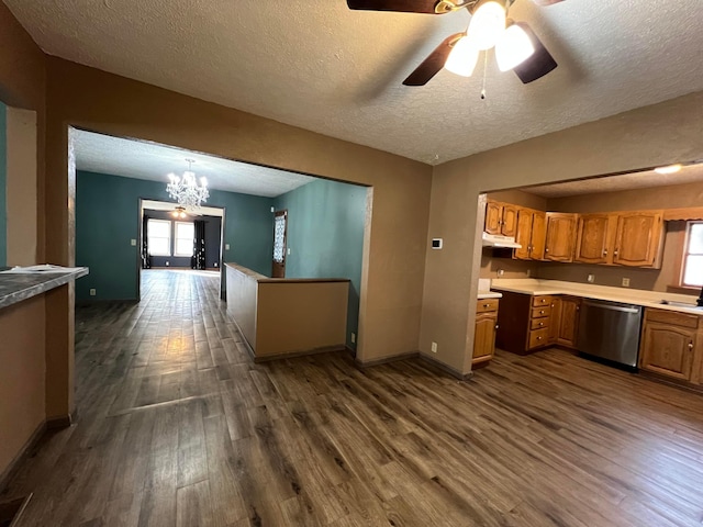 kitchen featuring pendant lighting, sink, stainless steel dishwasher, dark wood-type flooring, and a textured ceiling