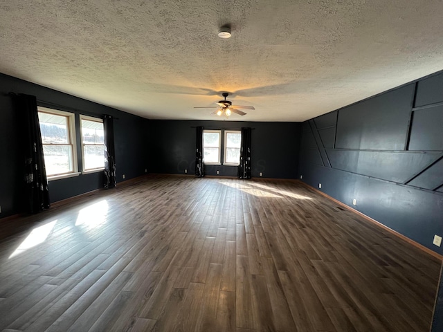 unfurnished room featuring ceiling fan, a textured ceiling, and dark hardwood / wood-style flooring