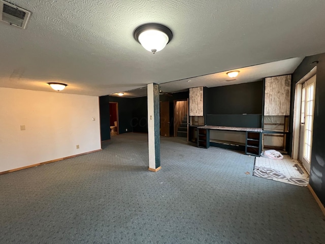 basement featuring carpet floors and a textured ceiling