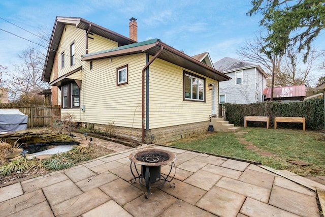 rear view of house featuring a patio area and an outdoor fire pit