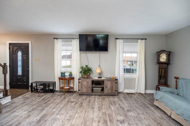 living area with baseboards, stairway, and wood finished floors