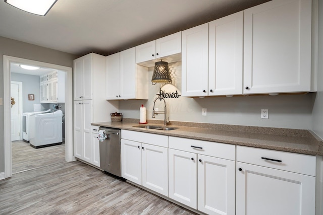 kitchen featuring stainless steel dishwasher, a sink, white cabinets, and washer and dryer