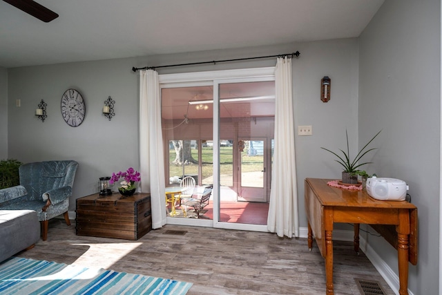 doorway to outside featuring baseboards, visible vents, and wood finished floors