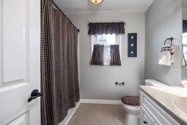 bathroom featuring toilet, a textured ceiling, vanity, baseboards, and tile patterned floors