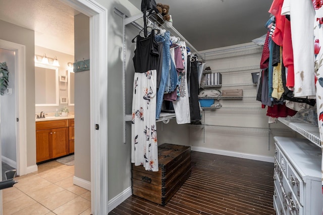 spacious closet featuring light tile patterned floors and a sink