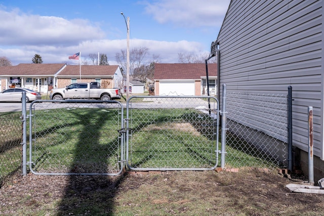 view of yard featuring a residential view, fence, and a gate