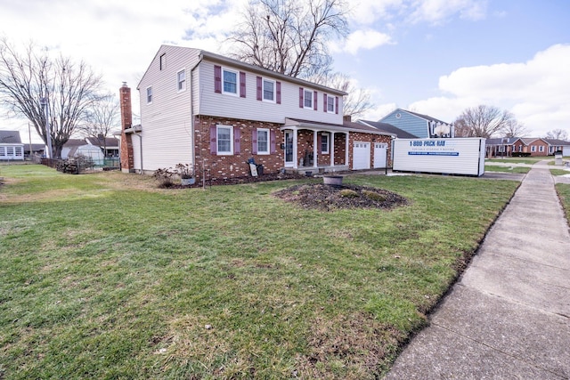 colonial house with a garage, brick siding, and a front lawn