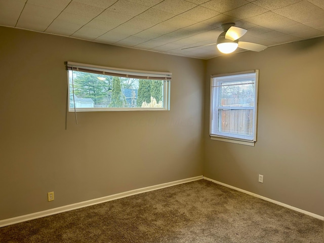 carpeted spare room featuring ceiling fan