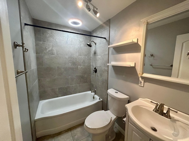 full bathroom featuring tile patterned flooring, vanity, tiled shower / bath, and toilet