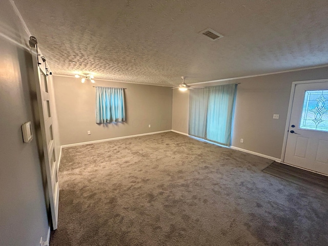 interior space featuring crown molding, ceiling fan, carpet floors, and a textured ceiling