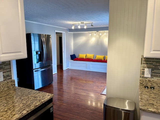 kitchen with white cabinetry, stainless steel refrigerator with ice dispenser, backsplash, and a textured ceiling