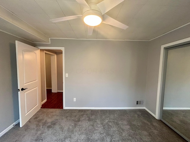 unfurnished room featuring ceiling fan and dark colored carpet