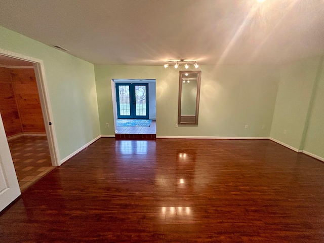 unfurnished living room featuring dark wood-type flooring and french doors