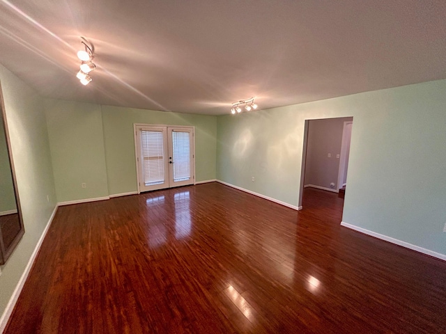 spare room featuring dark wood-type flooring and french doors