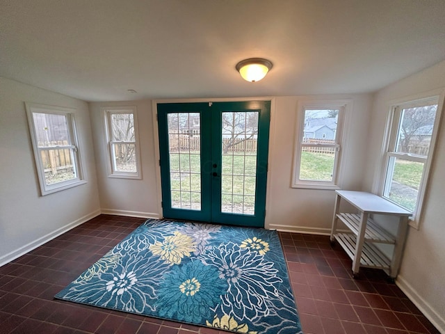 doorway to outside with french doors, a healthy amount of sunlight, and dark tile patterned floors