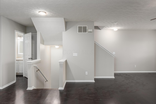 stairway with hardwood / wood-style flooring and a textured ceiling